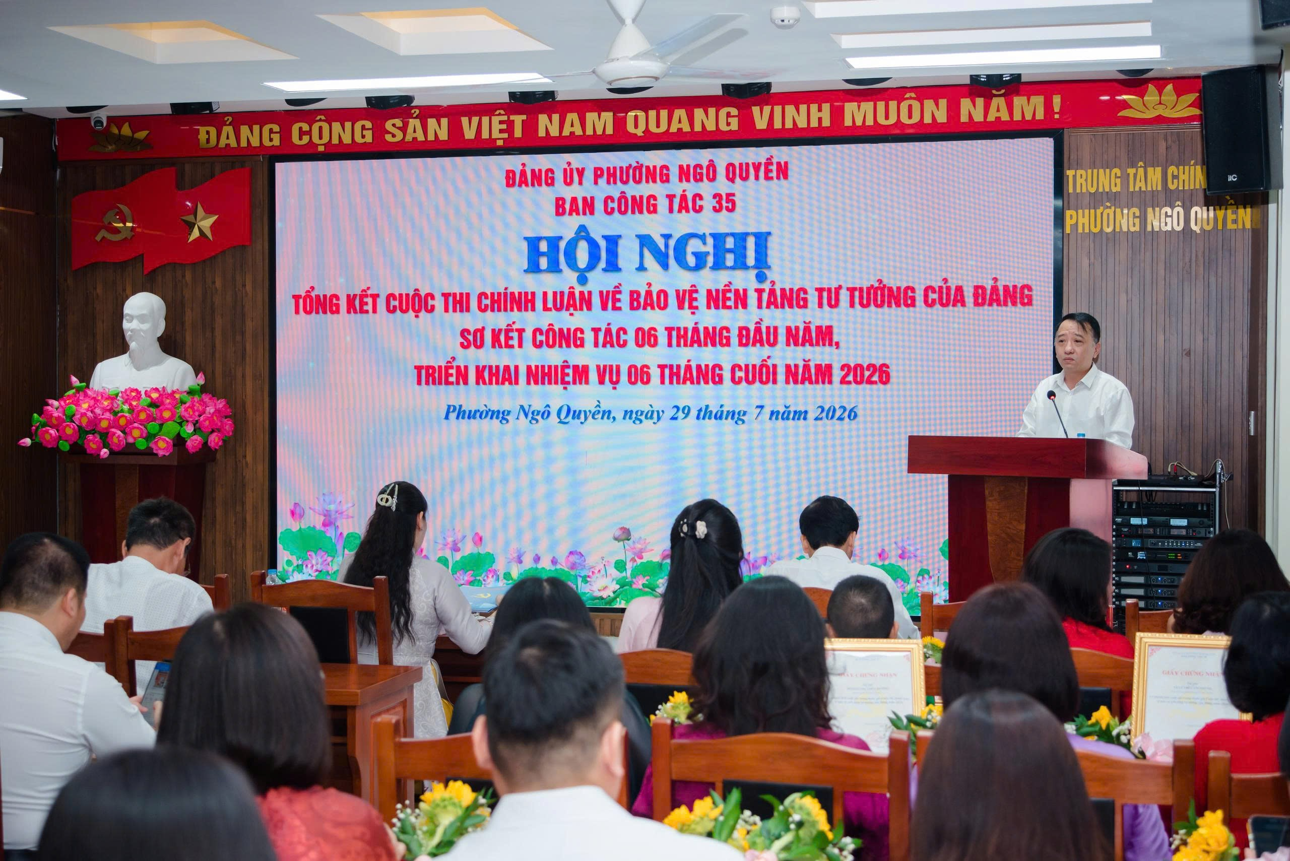 A group of people sitting in chairs in front of a screen

Description automatically generated